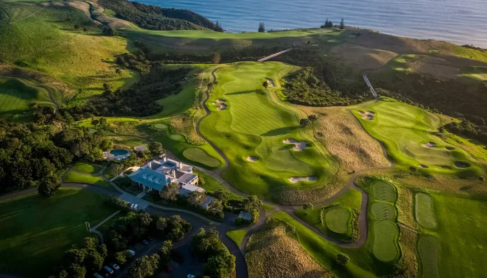 Aerial view of Kauri Cliffs Golf Course clubhouse and fairways overlooking the Bay of Islands, New Zealand