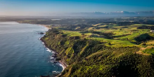 Aerial view of Kauri Cliffs Golf Course stretching along the rugged coastline of the Bay of Islands, New Zealand