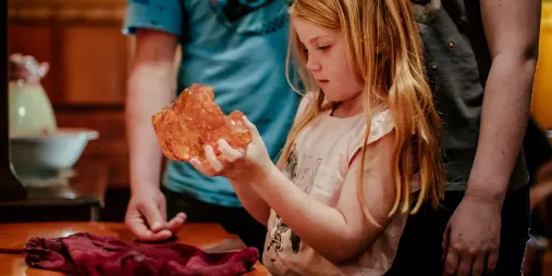 Young girl holding a large piece of kauri gum at The Kauri Museum
