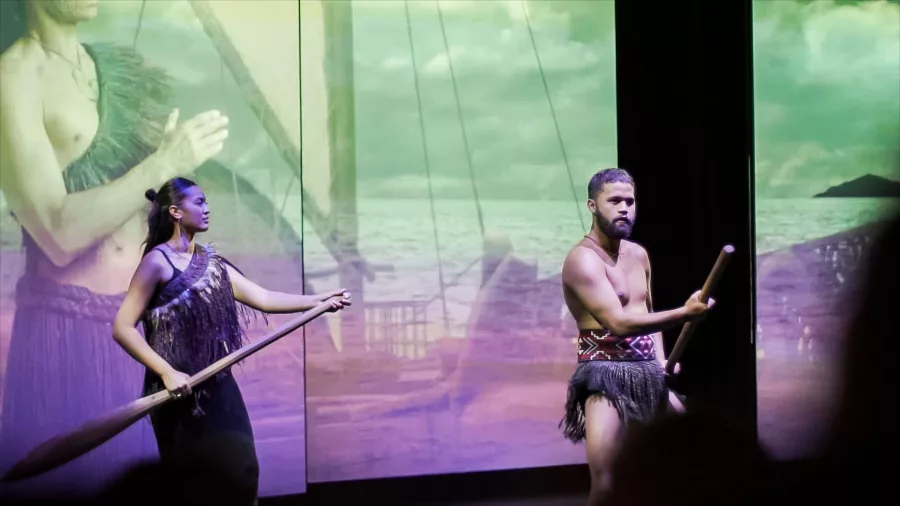 Māori performers with traditional paddles on stage during a 4D theatre reenactment of Kupe’s journey at Manea