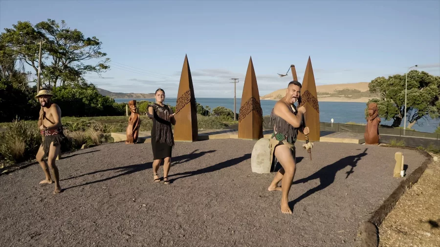 Māori performers presenting a traditional welcome with Hokianga Harbour in the background at Manea Lookout in Northland