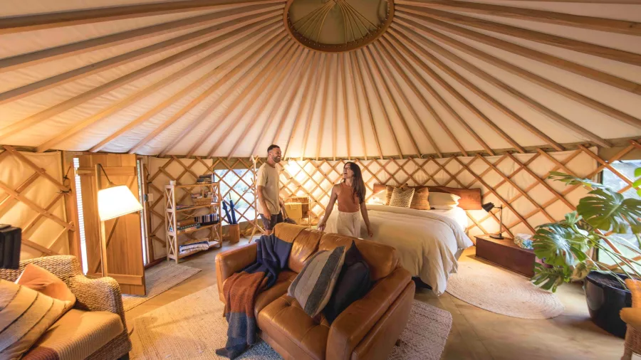Couple enjoying the cosy interior of a luxury glamping yurt in Matapouri, Northland