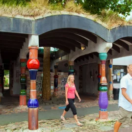 Tourists walking past the colourful and quirky Hundertwasser Toilets in Kawakawa