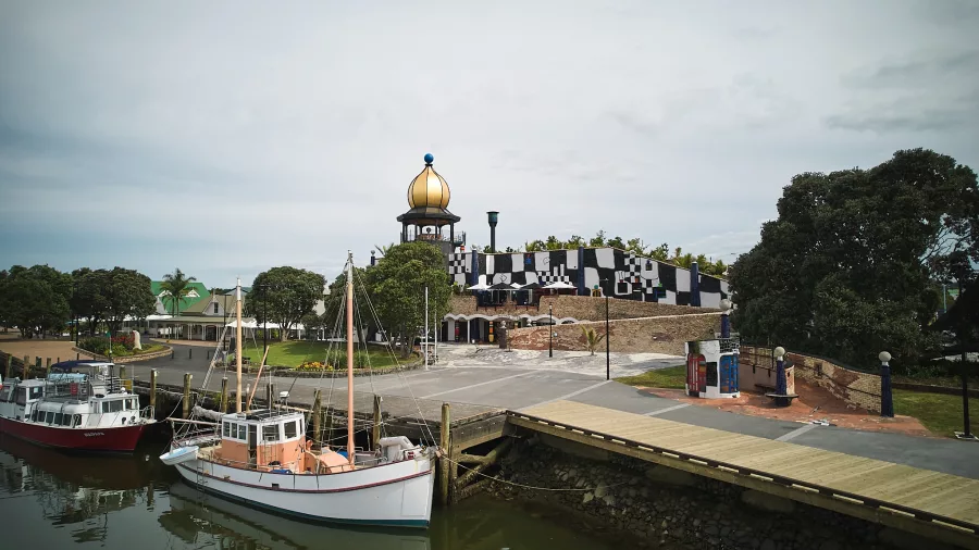 Waterfront view of the Hundertwasser Art Centre in Whangārei with boats docked nearby