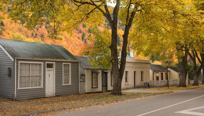Historic miners’ cottages in Arrowtown surrounded by golden autumn leaves