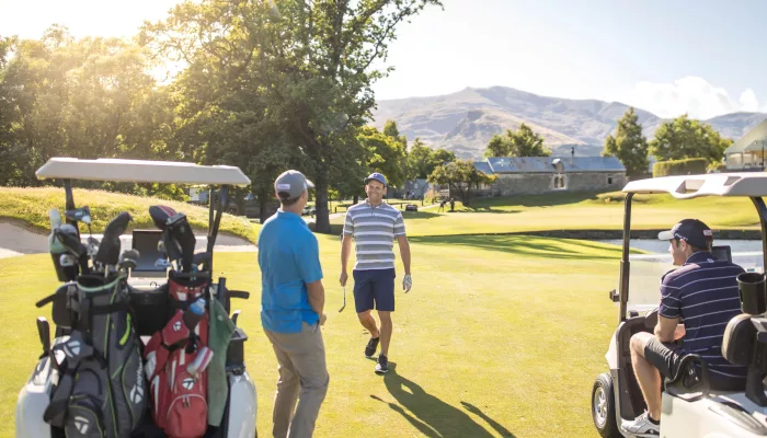 Golfers at Millbrook Resort Golf Course in Arrowtown, Queenstown, New Zealand, on a sunny day.