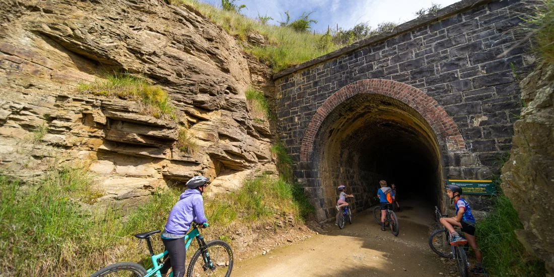 Trail users pausing at tunnel entrance on the Otago Central Rail Trail