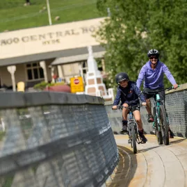Cyclist and child crossing footbridge at Hyde former railway station on rail trail