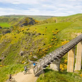 Cyclists riding over a viaduct bridge on the Otago Central Rail Trail near Middlemarch