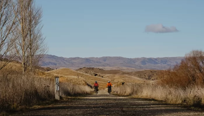 Family cycling through winter landscape on Otago Central Rail Trail