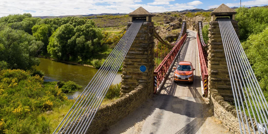 Vehicle crossing the Ophir Historic Bridge on the Central Otago Touring Route in New Zealand