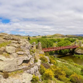 Landscape view of Ophir Bridge Road crossing the Manuherikia River on the Central Otago Touring Route in New Zealand