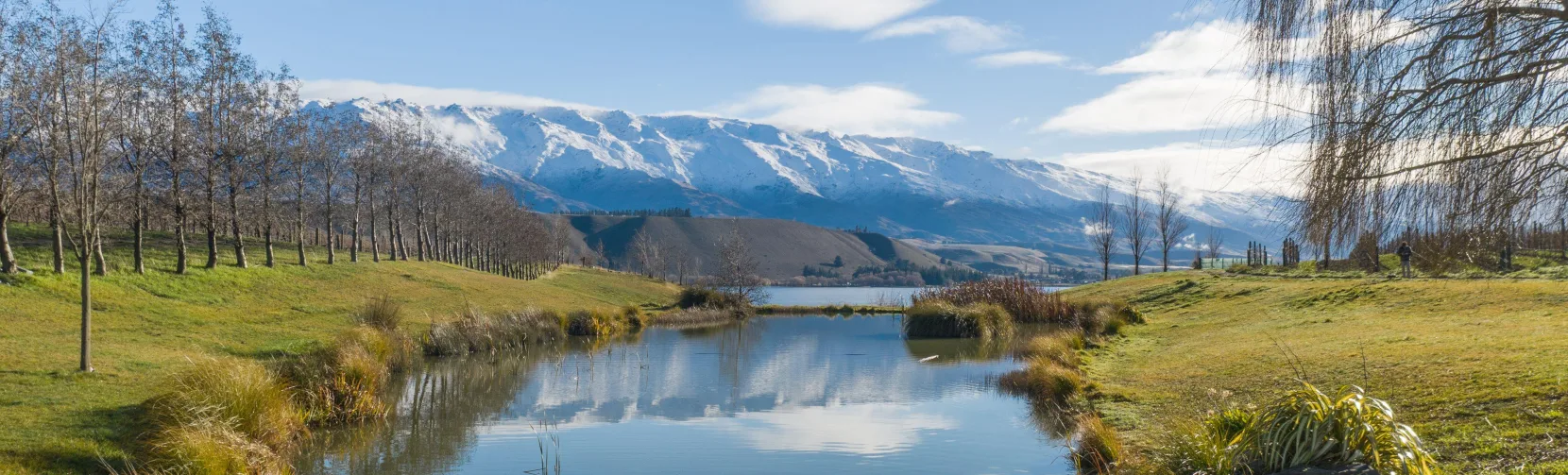 Scenic view of the Clutha River and snow-capped mountains from Cloudy Bay Shed in Cromwell, Central Otago, New Zealand