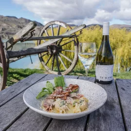Gourmet meal with a glass of Te Kano white wine served outdoors at Armando’s Kitchen in Cromwell, Central Otago, New Zealand