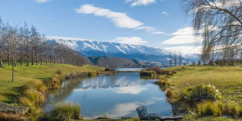 Scenic view of the Clutha River and snow-capped mountains from Cloudy Bay Shed in Cromwell, Central Otago, New Zealand