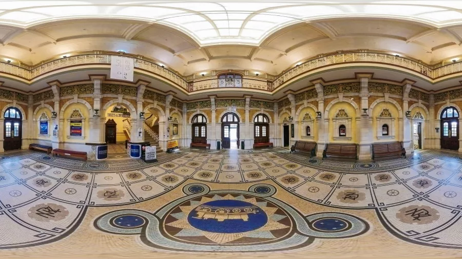 Lavish Royal Doulton mosaic floor inside Dunedin Railway Station, surrounded by ornate arches and upper balconies.