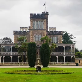 The stately front entrance and gardens of Larnach Castle in Dunedin, New Zealand.