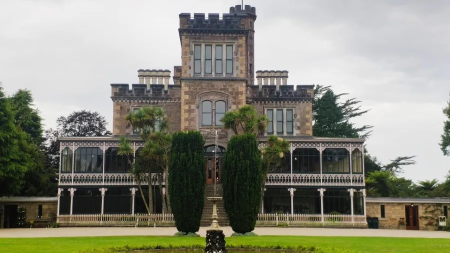 The stately front entrance and gardens of Larnach Castle in Dunedin, New Zealand.