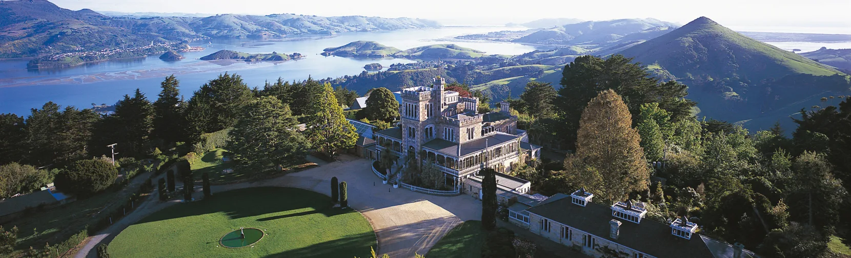 Aerial view of Larnach Castle and Gardens on the Otago Peninsula overlooking Otago Harbour, a Victorian heritage site in Dunedin, New Zealand