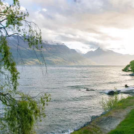 Lake Wakatipu in Queenstown before sunset with soft light over the mountains and trees