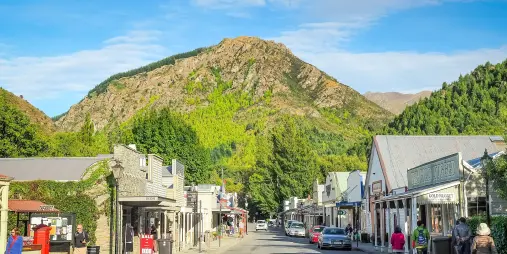 View of Arrowtown’s main street with boutique shops, heritage buildings and a mountain backdrop