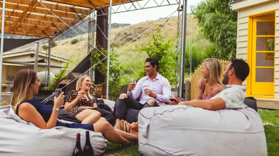 Group of friends relaxing on bean bags enjoying wine at Kinross Winery in Gibbston Valley