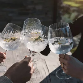 Four people toasting gin and tonic in large glasses at Cardrona Distillery, Queenstown Heli-Gin Tour.