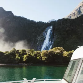 Waterfall in Milford Sound viewed from the deck of a cruise boat in Fiordland