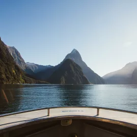 View from a boat sailing into Milford Sound with Mitre Peak rising ahead