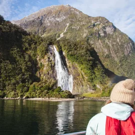 Travellers viewing Stirling Falls from a boat on Milford Sound