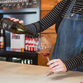 Pinot Noir being poured into a wine glass at Mt Rosa Winery during a tasting in Gibbston Valley