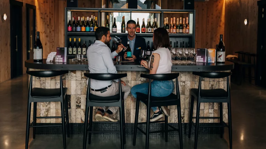 Couple enjoying a wine tasting at Kinross with a staff member guiding them through local wine selections