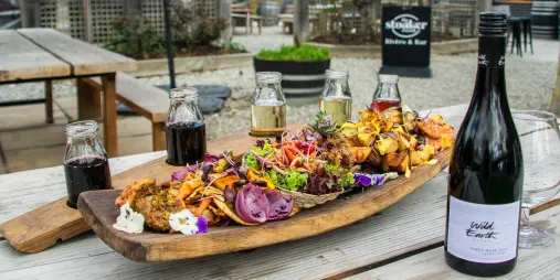 Gourmet food tasting platter paired with Wild Earth wine served outdoors at The Stoaker Room in Queenstown.