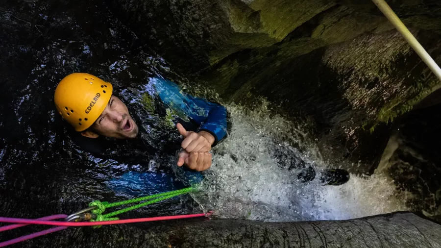 Canyoner giving thumbs up during waterfall descent