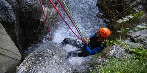 Participant abseiling beside waterfall at Camp Creek