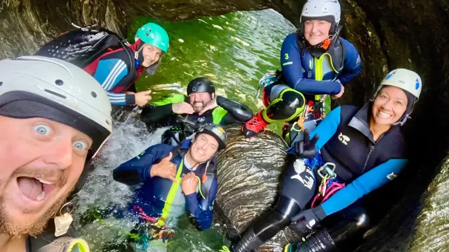 Group of canyoners taking a selfie inside a canyon tunnel