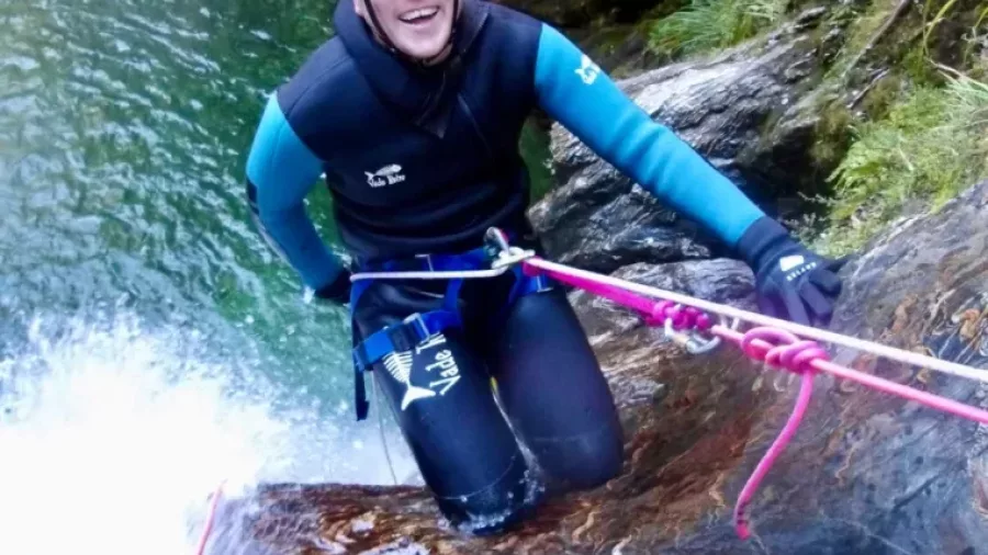 Canyoner smiling while abseiling on pink rope