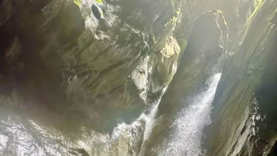 Powerful waterfall crashing into blue canyon pool