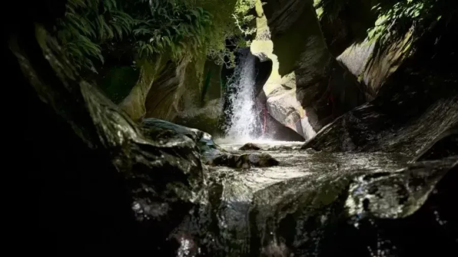 Sunlight shining through narrow canyon waterfall