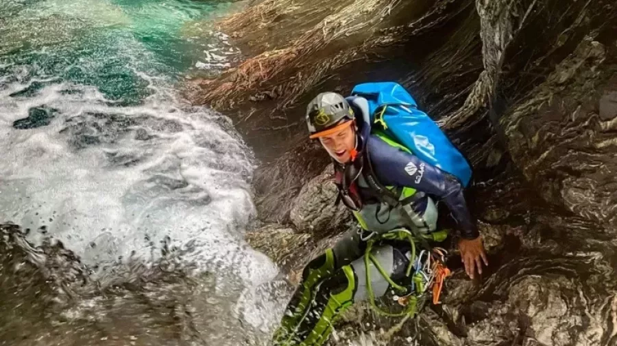 Canyoner descending slippery rocks in Mt Aspiring canyon