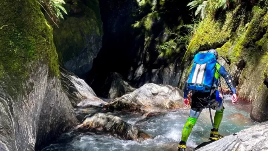 Canyoner approaching canyon entrance through stream