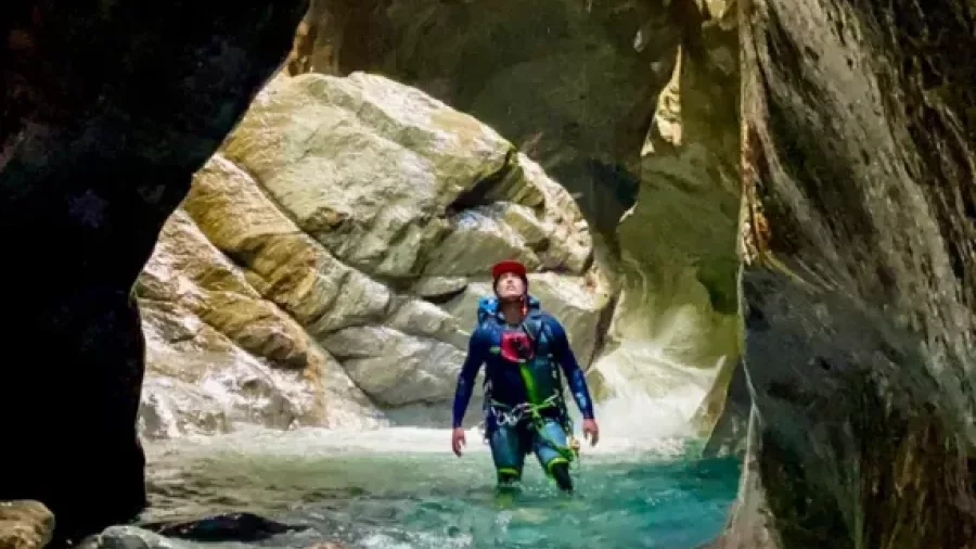 Canyoner walking through shallow canyon stream