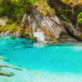 Hiker standing near Blue Pools with swing bridge in background