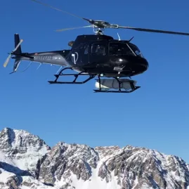 Helicopter flying above snow-capped peaks in Aoraki Mount Cook National Park