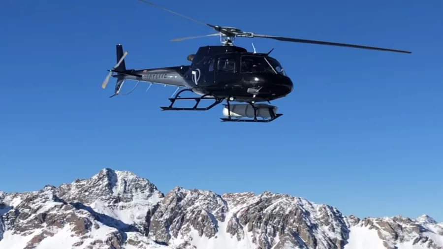 Helicopter flying above snow-capped peaks in Aoraki Mount Cook National Park