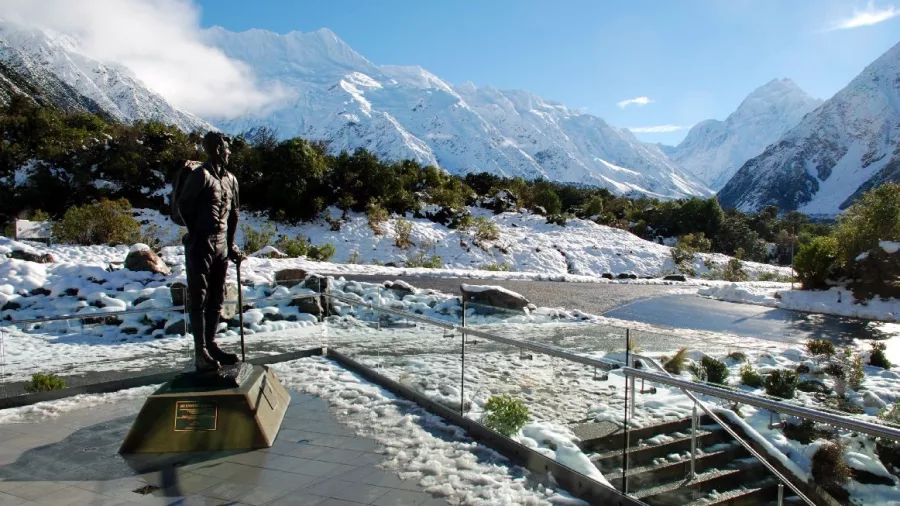 Statue of Sir Edmund Hillary in Mount Cook Village with snow-covered mountains behind