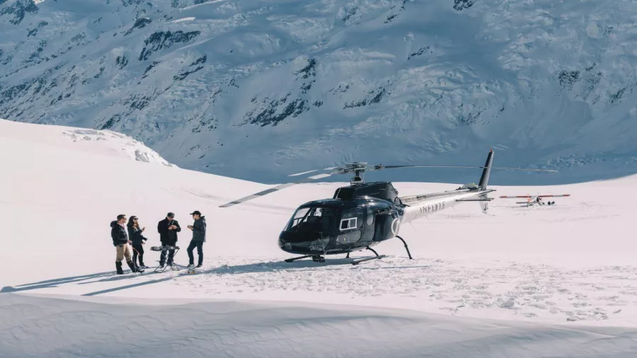 Helicopter with passengers landing in deep snow near Mount Cook
