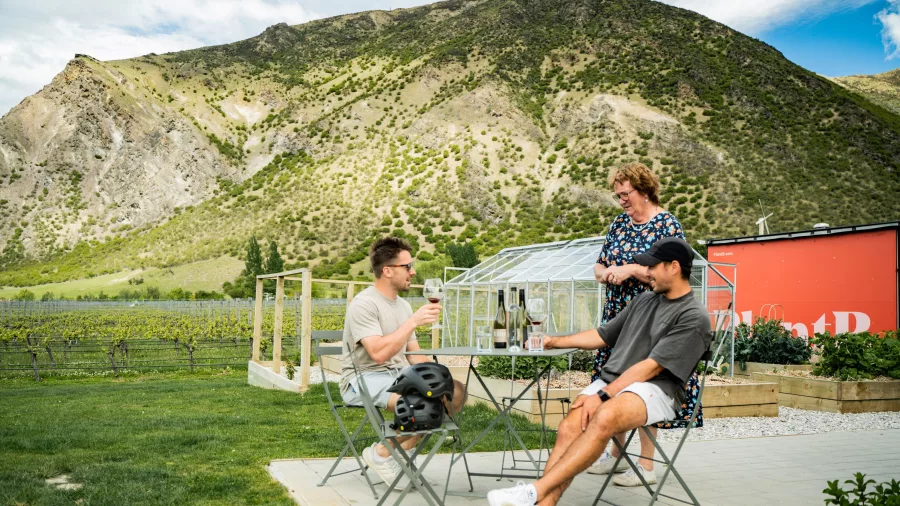 Guests enjoying a relaxed outdoor wine tasting at Mt Rosa Winery with vineyard and mountain views.