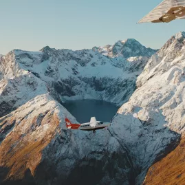 Glenorchy Air plane flying past Lake Erskine in the Fiordland mountains