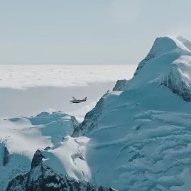 Scenic flight with Glenorchy Air passing dramatic snow-covered mountains above the clouds.